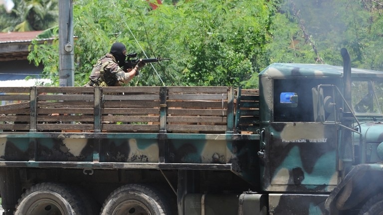A Philippine soldier on board a truck aims his weapon towards rebel positions in Zamboanga