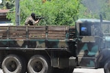 A Philippine soldier on board a truck aims his weapon towards rebel positions in Zamboanga