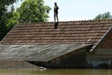 A man waits to be rescued from the roof of his house during heavy floods in Vojskova, Bosnia.