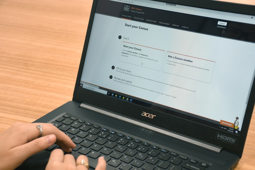An anonymous hand looks at a laptop with the census on it 