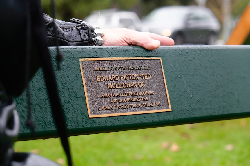 A park bench with a plaque.