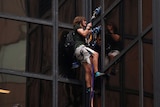 A man climbs the outside of Trump Tower.