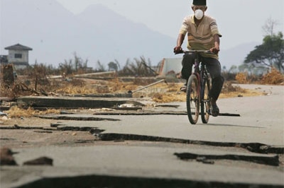 A man rides a bike through Banda Aceh after the 2005 tsunami