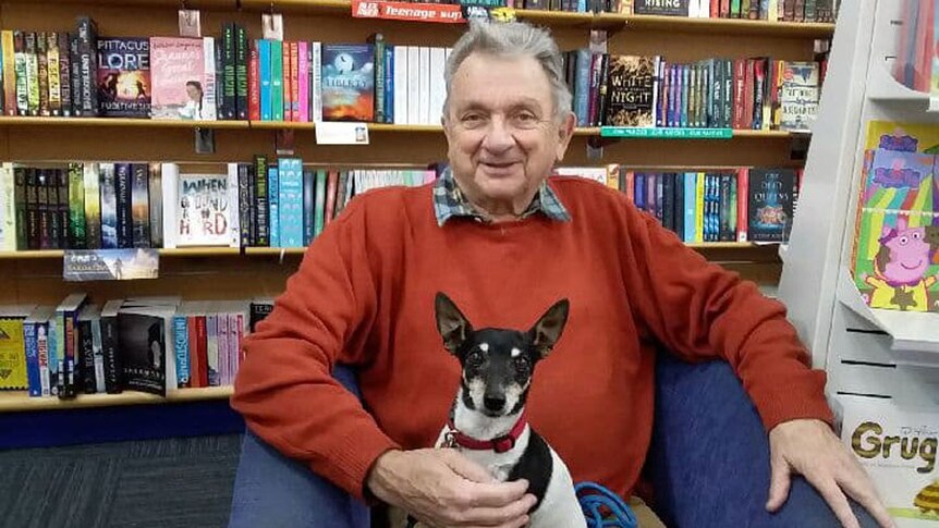 Pensioner Jim Jones, sitting with his dog Towser at a bookshop.