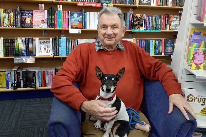 Pensioner Jim Jones, sitting with his dog Towser at a bookshop.