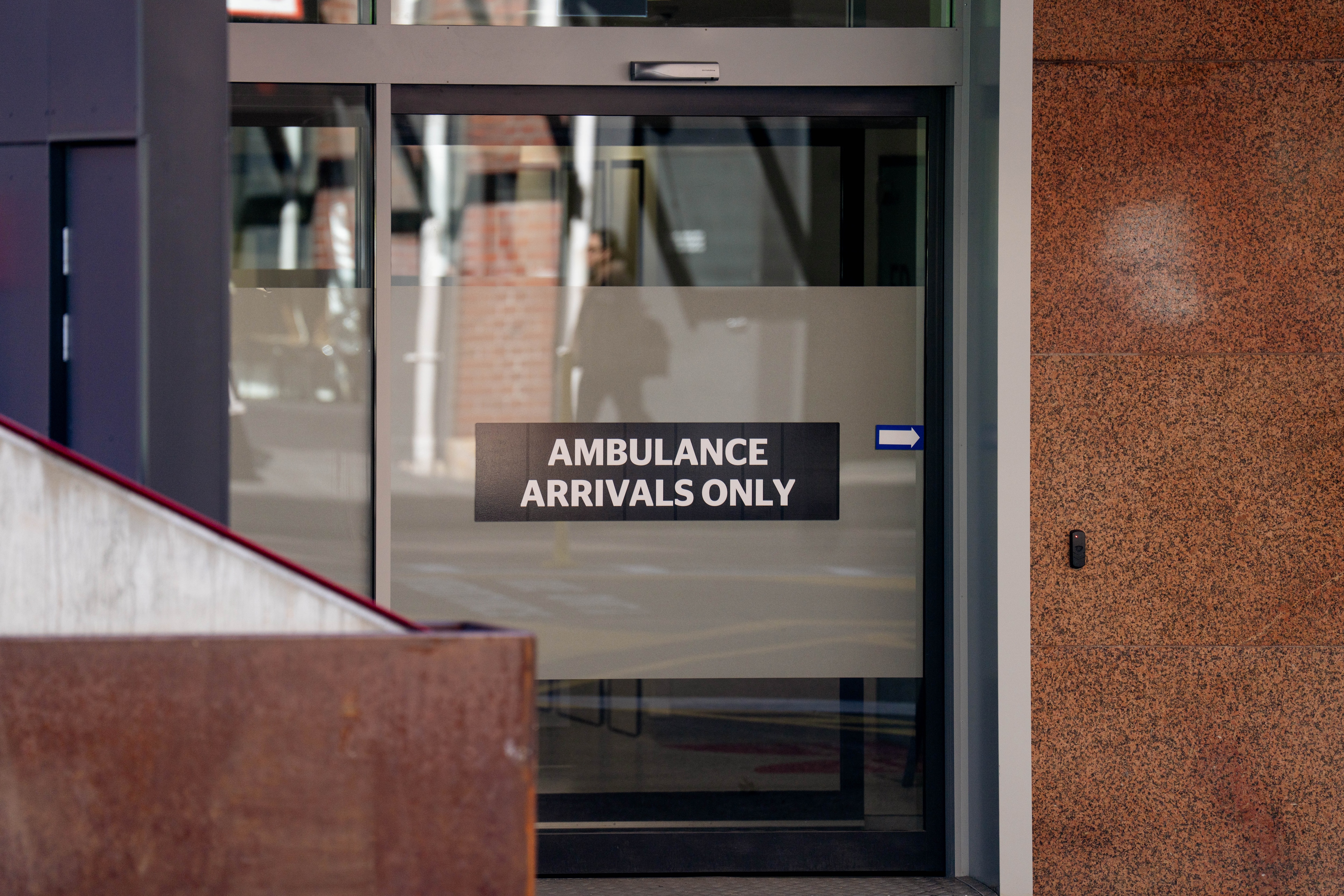 Signage on a glass door that says "AMBULANCE ARRIVALS ONLY".