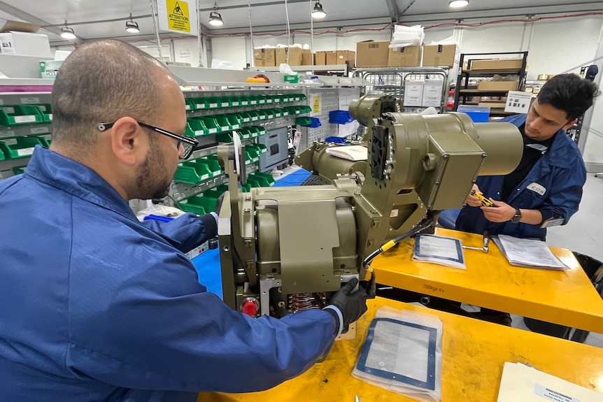 Two engineers in a lab testing a device.