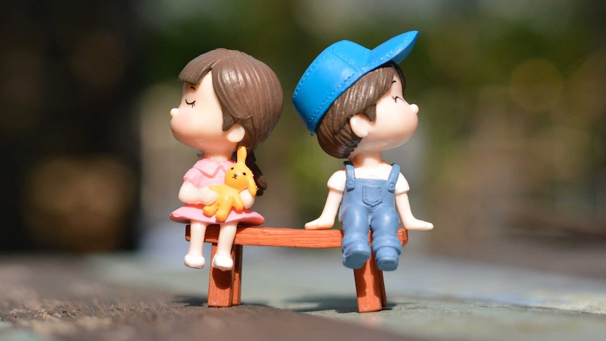 Boy and girl figurine looking away from one another
