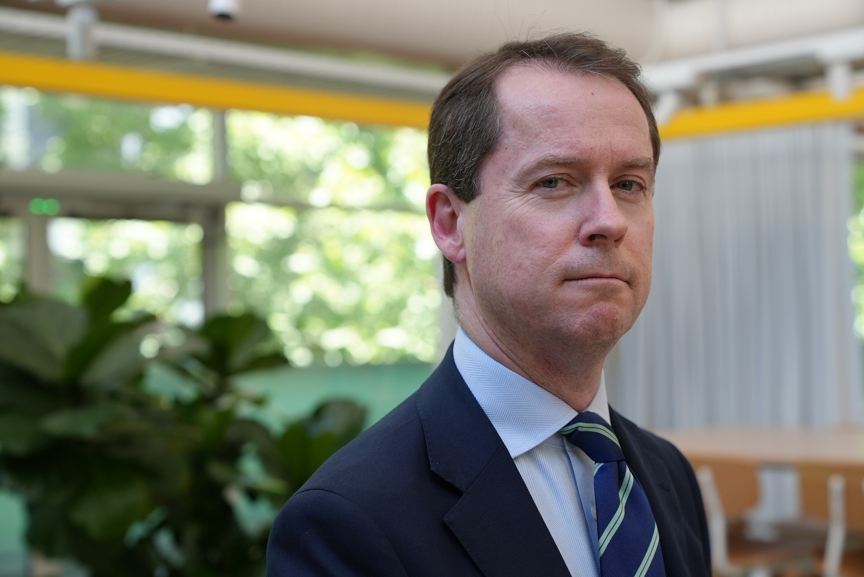 Un hombre de traje mira a la cámara.