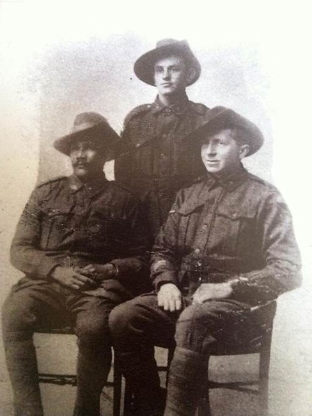 William Williams sits in uniform for a portrait with two other servicemen