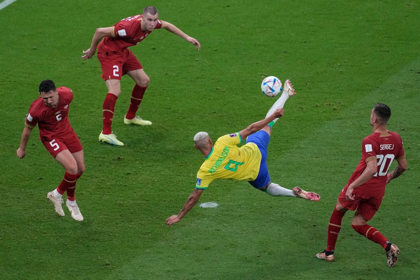 Brazil's Richarlison connects with a scissor kick as three Serbian defenders surround him during the World Cup in Qatar.