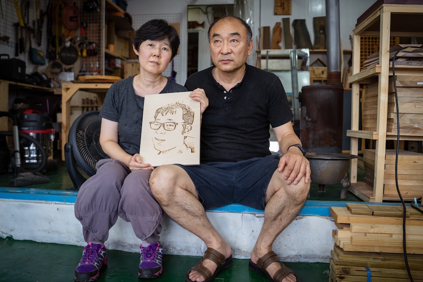 Jang Deok-joon's parents hold a portrait of their son.