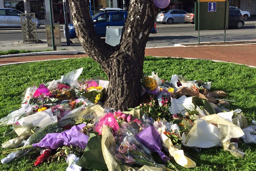 Flowers under a tree in tribute to Voula Delios