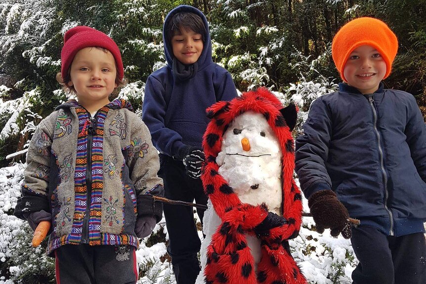 Three kids and a snowman.
