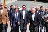 A group of male mining executives walking down a Perth street.