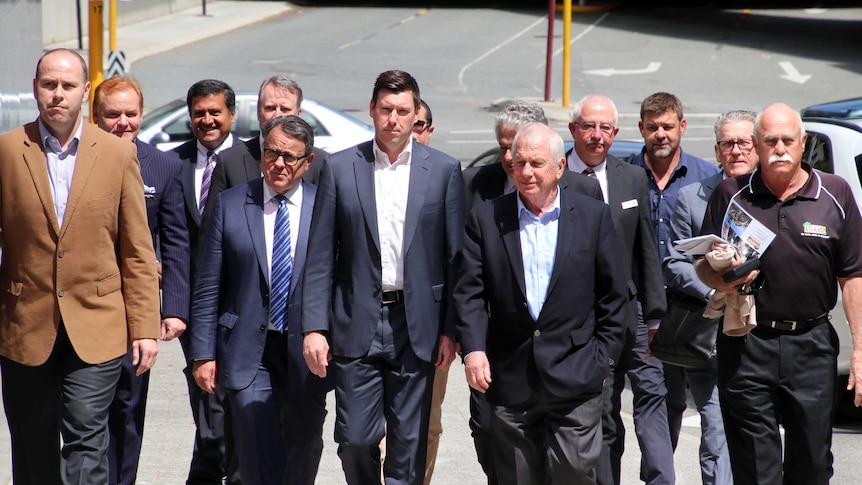 A group of male mining executives walking down a Perth street.