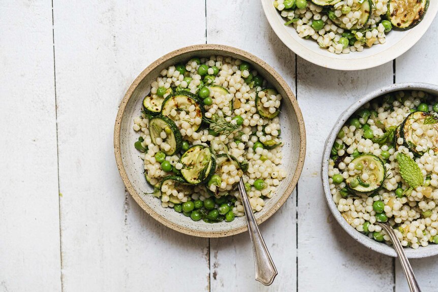Three bowls of charred zucchini and pearl couscous salad