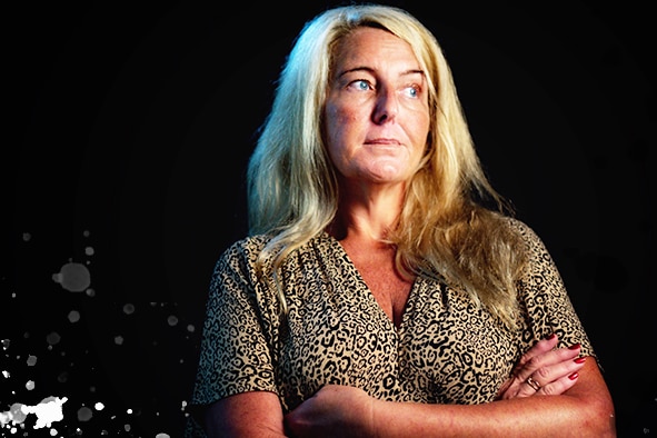 Nicola Gobbo stands with her arms crossed with a black background