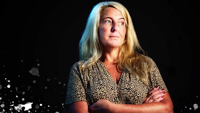 Nicola Gobbo stands with her arms crossed with a black background