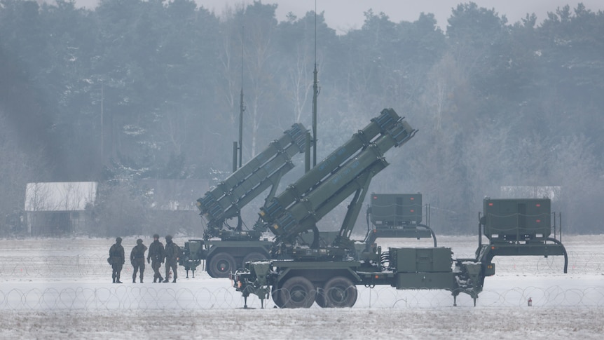 Patriot missile launchers sit in a snow-covered field.