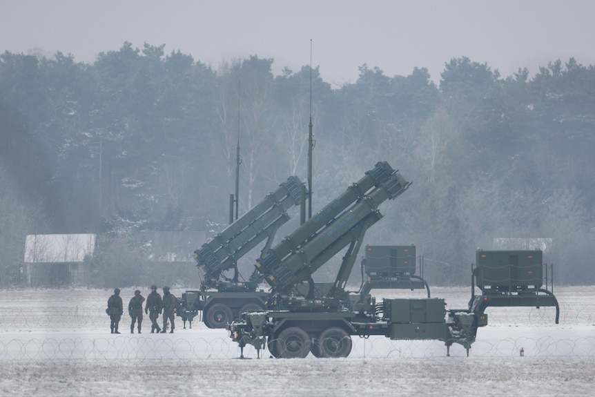 Patriot missile launchers sit in a snow-covered field.