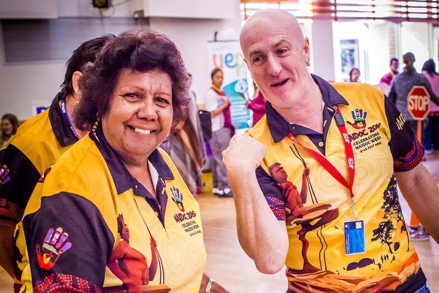 Aunty Lillian Burke and Sean Connelly in yellow NAIDOC shirts