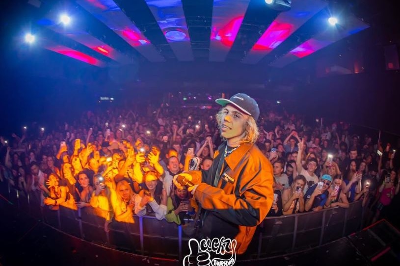 A photo of rapper The Kid Laroi performing at a nightclub.