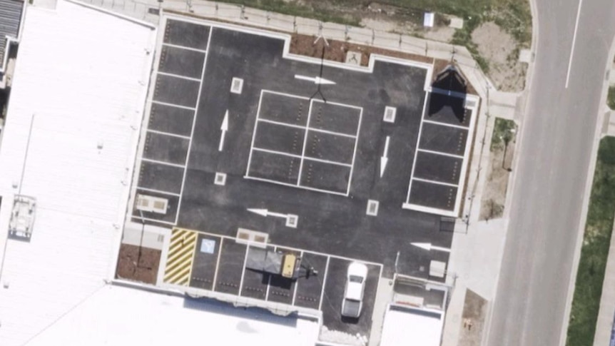 Birds eye view of a car park with arrows pointing in a circle 