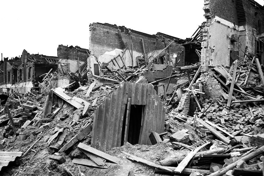 A corrugated iron doorway rises from the debris of a bombed neighbourhood 