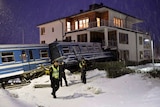 Policemen stand in front of a local train that derailed into a residential building in Saltsjoebaden, Sweden.