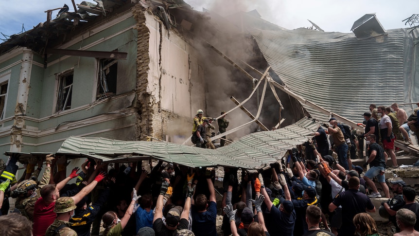 Dozens of people holding up the roof of a building crumbling down after a missile strike 
