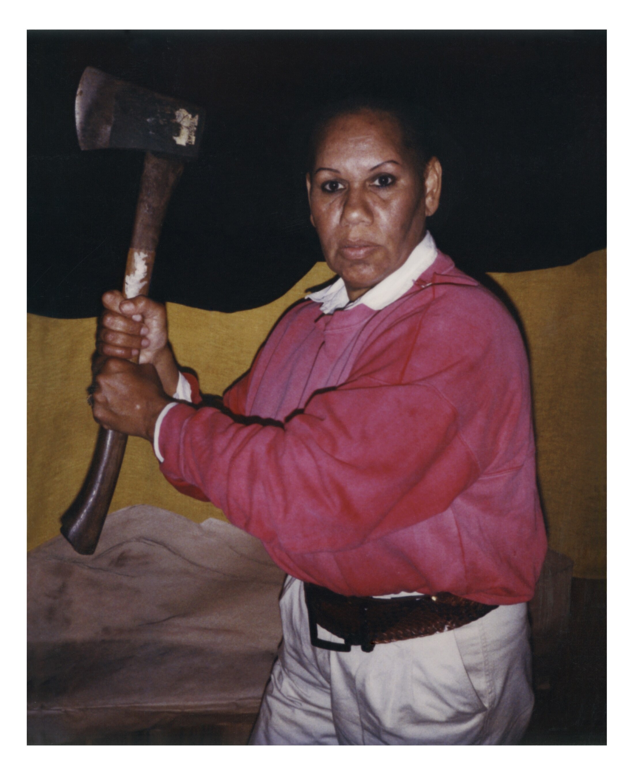 A 90s photograph of the Aboriginal writer Eva Johnson wielding an axe