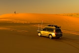 Four wheel drive vehicle travelling through a desert landscape