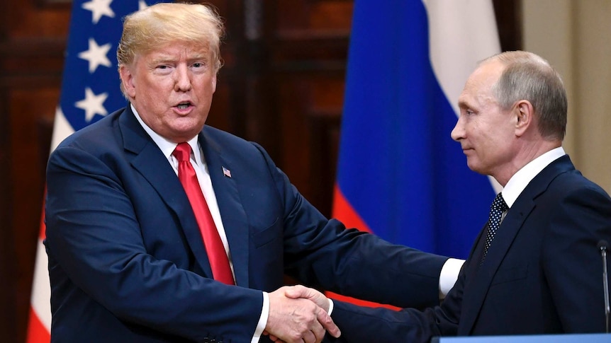 Donald Trump shakes hands with Vladimir Putin, both standing in front of US and Russian flags with a lectern labelled 'Helsinki'