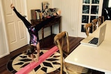 Child doing gymnastics in front of her computer