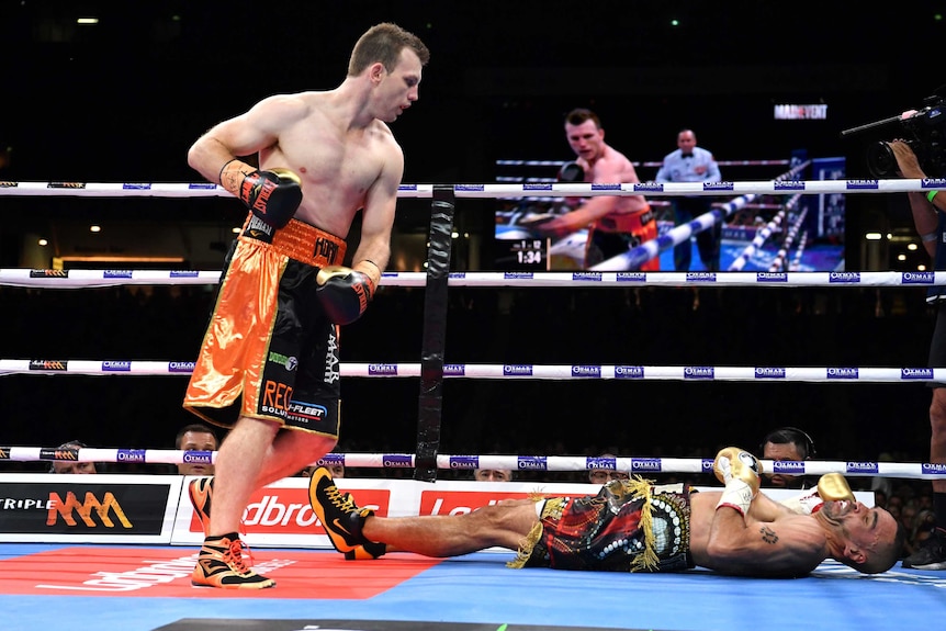 Jeff Horn looks over Anthony Mundine on the canvas