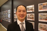 A real estate agent in front of a window display of houses for sale