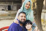Hansanul Bunna Khan with his wife Tashfia and son Nayel pose for a picture by a tree