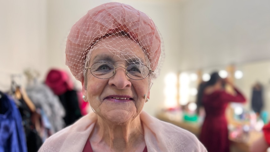 An elderly woman dressed in a 1950s hat with veil