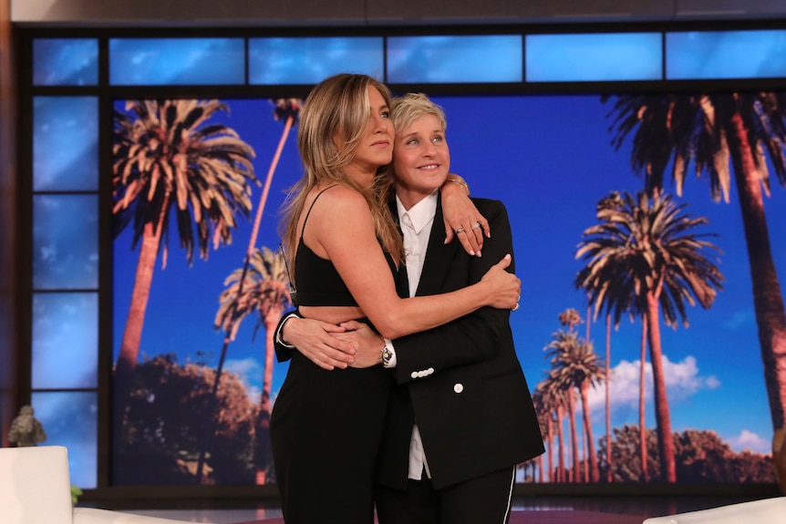 Ellen and Jennifer Aniston embrace on stage.