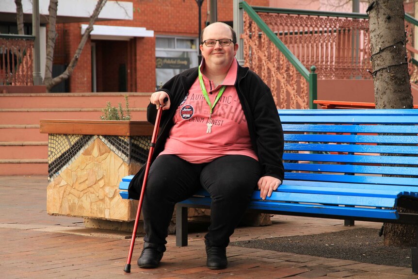 Disability advocate Cody Jones pictured on a park bench in Dubbo.