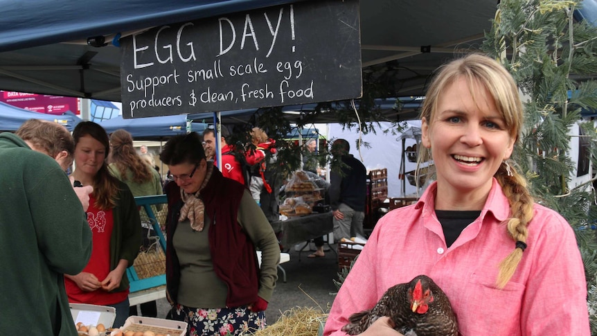 Tasmanian market gardener Paulette Whitney holds a free range chicken.