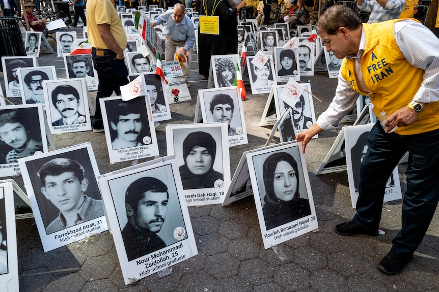 Images of deceased political prisoners stand in the midst of a protest as Iranian Americans.