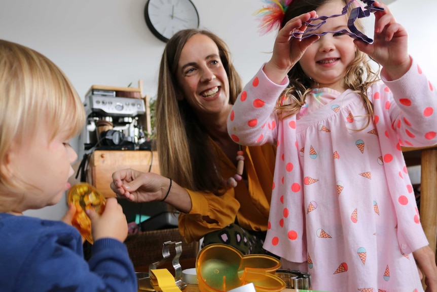 Mum with her two small children in their home