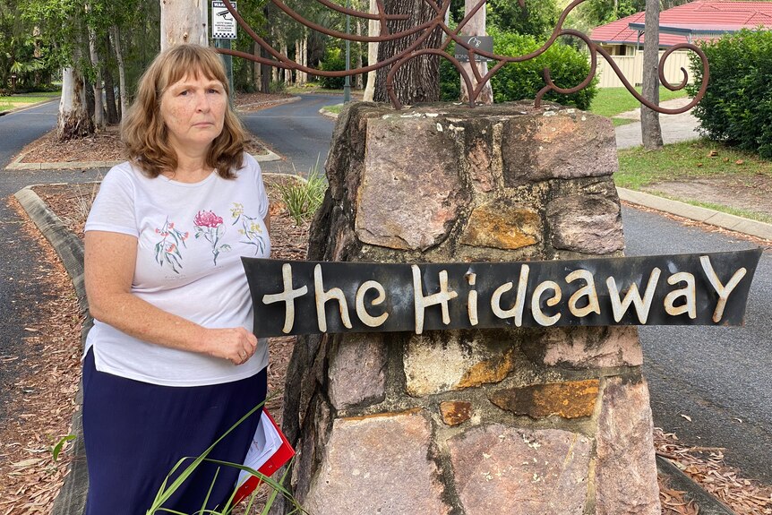 Leah Campbell stands at the entrance sign to The Hideaway estate at Burpengary, north of Brisbane.