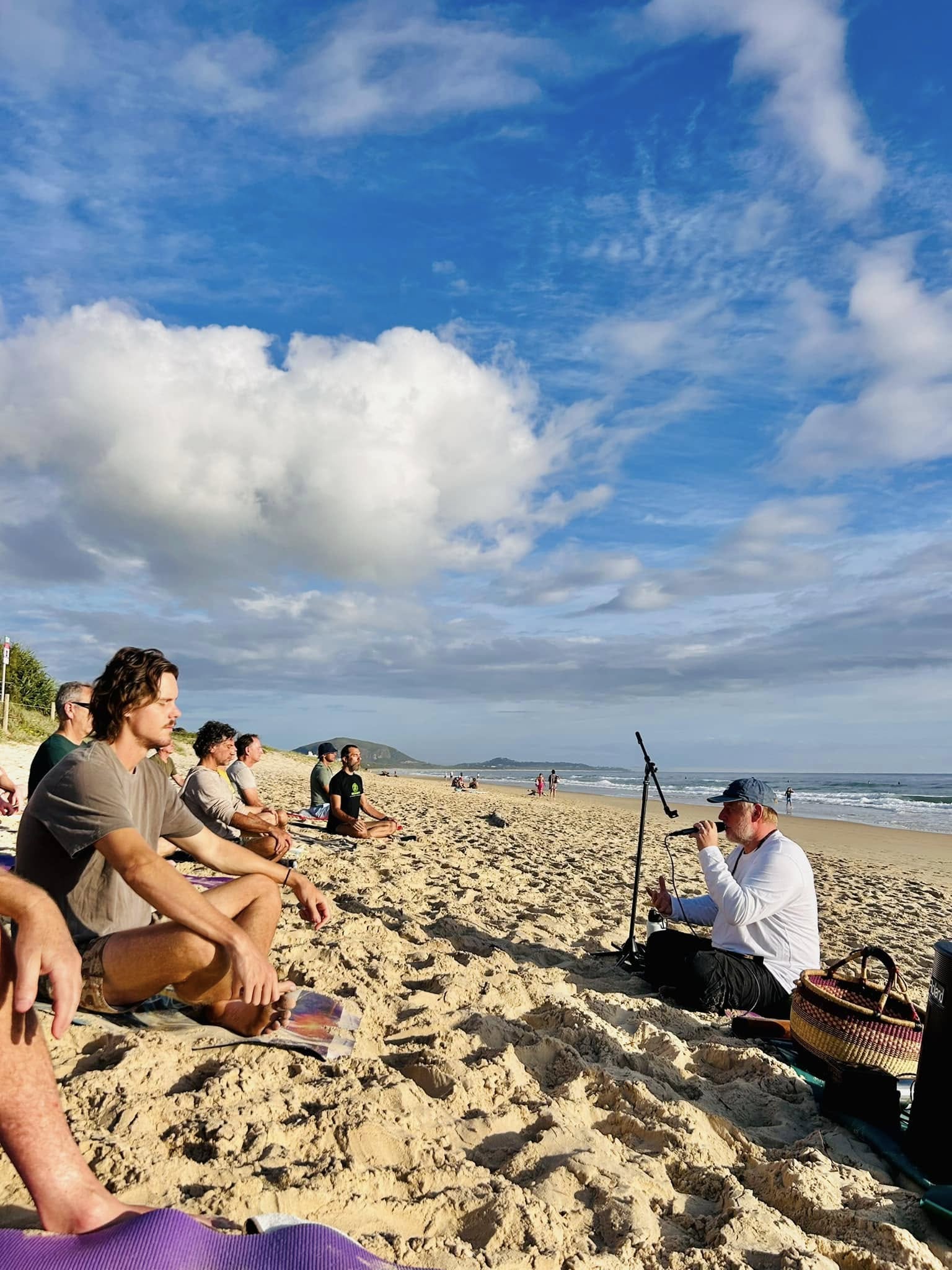 Men meditating on the beach