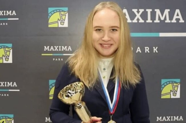 A young blonde holding a trophy 