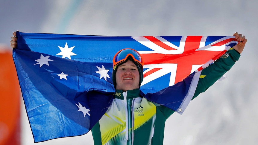 Jarryd Hughes celebrates his snowboard cross silver medal with the Australian flag in Pyeongchang.