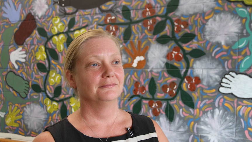 Outreach worker Pauline Reynolds stands in front of a mural in Tennant Creek.