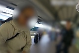 A blurred face of a woman wearing a grey hoodie